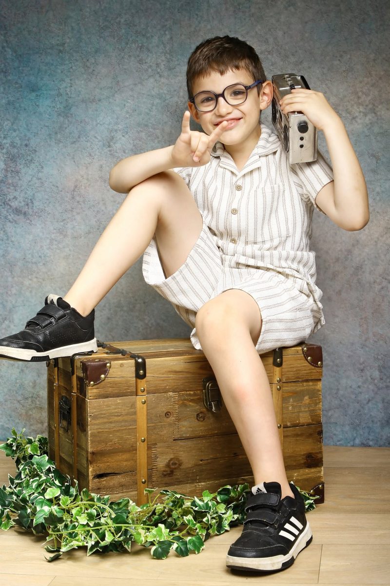enfant assis sur une valise dans le studio photo de Virgin'arts à St-Hilaire-des-loges